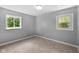 Bright bedroom features two windows providing natural light and neutral carpet at 9319 Rochelle Dr, Indianapolis, IN 46235