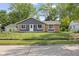 Charming single-story home featuring gray siding, brick accents, and a well-maintained front yard with mature trees at 9319 Rochelle Dr, Indianapolis, IN 46235
