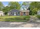 Charming single-story home featuring gray siding, brick accents, and a well-maintained front yard with mature trees at 9319 Rochelle Dr, Indianapolis, IN 46235