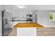 Open kitchen with white cabinets, wood island, stainless steel appliances, and new floors at 9319 Rochelle Dr, Indianapolis, IN 46235