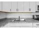 Close up of kitchen sink, counter, and backsplash showcasing clean lines and neutral colors at 9319 Rochelle Dr, Indianapolis, IN 46235