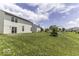 View of the backyard with a very large lawn and the white house with a sliding glass door at 9665 Gull Lake Dr, Indianapolis, IN 46239