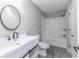 Bright bathroom with modern vanity, oval mirror, and tub with shower at 9665 Gull Lake Dr, Indianapolis, IN 46239