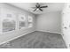 This is a bedroom with gray walls and gray carpet with a ceiling fan and three windows at 9665 Gull Lake Dr, Indianapolis, IN 46239