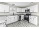 Modern kitchen features white cabinets, stainless steel appliances, and granite countertops with durable flooring at 9665 Gull Lake Dr, Indianapolis, IN 46239