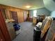 Unfinished attic space with paneled walls, gray carpet and dormer window provide potential for storage or remodeling at 9721 S 100 E, Pendleton, IN 46064