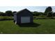 Detached one car garage with light gray siding and white door on a large lawn at 9721 S 100 E, Pendleton, IN 46064