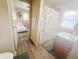 Clean bathroom featuring vanity, shower with decorative curtain, and view to bedroom at 1002 S Fleming St, Indianapolis, IN 46241