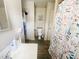 Well-maintained bathroom with vanity, toilet, and a shower with a decorative curtain at 1002 S Fleming St, Indianapolis, IN 46241