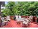 A bright and spacious deck with outdoor dining furniture and grill, surrounded by mature trees at 10381 Beaver Ridge Dr, Fishers, IN 46037