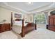 Serene main bedroom featuring a four-poster bed, tray ceiling, and ample natural light from a large window at 10381 Beaver Ridge Dr, Fishers, IN 46037