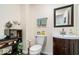 Well-appointed powder room with a modern vanity, decorative mirror, and convenient toilet at 10381 Beaver Ridge Dr, Fishers, IN 46037