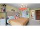 Bright bedroom features a striped duvet cover, unique lighting, and whimsical wall decor at 10594 Geist Rd, Fishers, IN 46037