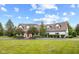 Sprawling two-story home featuring a red front door, mature trees, and a pristine lawn at 10594 Geist Rd, Fishers, IN 46037
