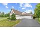 Exterior of a home featuring an attached three-car garage and lush landscaping at 10594 Geist Rd, Fishers, IN 46037