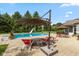 Backyard pool area with lounge chairs, patio umbrella, and well-manicured landscaping at 10594 Geist Rd, Fishers, IN 46037