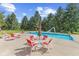 Backyard swimming pool with lounge chairs and dining set on a concrete patio and green surroundings at 10594 Geist Rd, Fishers, IN 46037