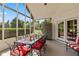 Comfortable screened-in porch with glass top dining table and view of the landscaped backyard at 10594 Geist Rd, Fishers, IN 46037