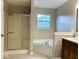 Bathroom featuring a shower, tub, vanity, and window that offers natural light at 11154 Schoolhouse Rd, Fishers, IN 46037