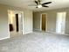 Bedroom with neutral walls, carpet, ceiling fan, with open doorways to closets and another room at 11154 Schoolhouse Rd, Fishers, IN 46037