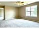 Bedroom with neutral paint, ceiling fan, carpet, and large window bringing in natural light at 11154 Schoolhouse Rd, Fishers, IN 46037