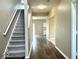 Hallway features hardwood floors, access to the stairs, kitchen, and other rooms in the house at 11154 Schoolhouse Rd, Fishers, IN 46037