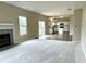 Open-concept living room with fireplace, carpet and kitchen in the background at 11154 Schoolhouse Rd, Fishers, IN 46037