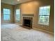 Cozy living room featuring plush carpeting, a fireplace, and three windows for natural light at 11154 Schoolhouse Rd, Fishers, IN 46037