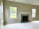 A living room featuring a decorative fireplace with gray tile, large windows, and neutral walls at 11154 Schoolhouse Rd, Fishers, IN 46037