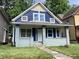 Charming blue two-story home with a brick-based porch and well-kept front lawn at 1125 N Rural St, Indianapolis, IN 46201