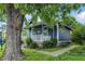 Cozy blue home with white trim, featuring a porch and mature trees at 1151 S Randolph St, Indianapolis, IN 46203