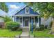 Charming blue home with white trim, front porch, and well-maintained landscaping at 1151 S Randolph St, Indianapolis, IN 46203