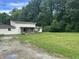 Two-story home featuring a covered front porch, spacious yard and gravel driveway at 1330 Schleicher Ave, Indianapolis, IN 46229