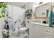 Well-lit bathroom featuring white vanity, decorative mirror, and shower with floral curtain at 1346 N Buck Creek Rd, Greenfield, IN 46140