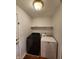 Well-lit laundry room features updated washer and dryer appliances, a shelf and access to the exterior at 1633 Belfield St, Indianapolis, IN 46217