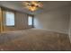 Large carpeted main bedroom with two windows offering natural light, along with a ceiling fan at 1633 Belfield St, Indianapolis, IN 46217