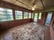 Enclosed sunroom featuring multiple windows, a ceiling fan, and a decorative rug at 1633 Belfield St, Indianapolis, IN 46217