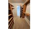 Spacious walk-in closet featuring wood shelving and neutral carpeting providing ample storage space at 1633 Belfield St, Indianapolis, IN 46217