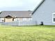 A spacious backyard featuring a well-maintained lawn and partial privacy fence at 1706 Creekwater Pass, Greenfield, IN 46140