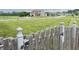Charming suburban neighborhood street view with a well-maintained lawn and wooden fence at 1706 Creekwater Pass, Greenfield, IN 46140