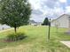 Green lawn, trees, and yellow lillies decorate the front yard of the suburban home at 1706 Creekwater Pass, Greenfield, IN 46140