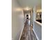 Inviting hallway with wood-look flooring, leading to a cozy living area with a stone fireplace at 1706 Creekwater Pass, Greenfield, IN 46140