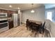 Kitchen with stainless steel appliances, wood floors, and a dining table with seating for four at 1706 Creekwater Pass, Greenfield, IN 46140