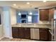 Modern kitchen featuring granite countertops, stainless steel appliances, and an open view into the living room at 1706 Creekwater Pass, Greenfield, IN 46140