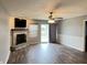 Bright living room with gray walls, featuring a stone fireplace and sliding glass door to the outdoors at 1706 Creekwater Pass, Greenfield, IN 46140