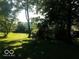 View of a backyard with lush green grass and mature trees surrounding the property at 18378 Southeastern Pkwy, Fortville, IN 46040