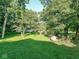 View of a large backyard with mature trees and lush grass, offering a serene and private outdoor space at 18378 Southeastern Pkwy, Fortville, IN 46040