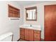 Bathroom featuring a vanity with storage, a mirror, and a shelf on the wall; and a door on the right at 18378 Southeastern Pkwy, Fortville, IN 46040