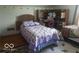 Bedroom with a patchwork quilt, adjacent built-in desk area with shelves, carpeted floors, and unique leaf accents at 18378 Southeastern Pkwy, Fortville, IN 46040