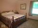 Cozy bedroom featuring a comfortable bed with a quilted coverlet, a window with curtains, and a wooden headboard at 18378 Southeastern Pkwy, Fortville, IN 46040